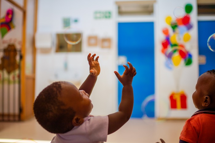 baby reaching up into the air